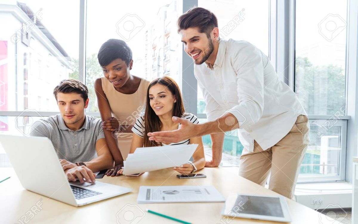 61584143-group-of-happy-young-business-people-using-laptop-and-working-together-in-office